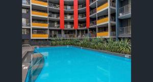 a large apartment building with a swimming pool in front of it at ARENA RESORT STYLE EXEC FREE NETFLIX WIFI WINE in Perth