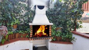 un horno de pizza con fuego en su interior en Ático Bcn, terraza y BBQ, Park Güell, en Barcelona