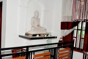 uma estátua sentada numa prateleira numa sala em Sumimal Resort Polhena em Matara