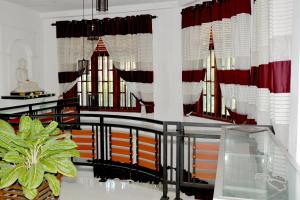 una habitación con cortinas rojas y blancas y un edificio en Sumimal Resort Polhena, en Matara