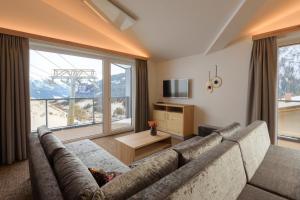 salon z kanapą i dużym oknem w obiekcie Arula GmbH w mieście Sankt Anton am Arlberg +16 zdjęć