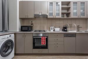 a kitchen with a stove and a washing machine at Goldcentral Apartment Akacfa in Budapest