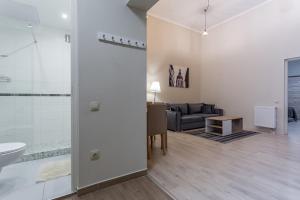 een woonkamer met een bank, een wastafel en een badkamer bij Goldcentral Apartment Akacfa in Boedapest