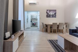 een woonkamer met een televisie en een eetkamer bij Goldcentral Apartment Akacfa in Boedapest