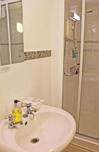 een badkamer met een wastafel en een douche bij The Cottage B&B in Porlock