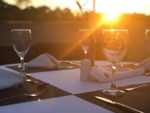 einen Tisch mit Gläsern Wein auf einem Tisch mit Sonnenuntergang in der Unterkunft Blue Tree Towers Valinhos in Valinhos