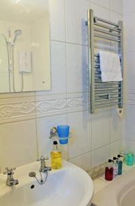 a bathroom with a white sink and a mirror at The Cottage B&B in Porlock