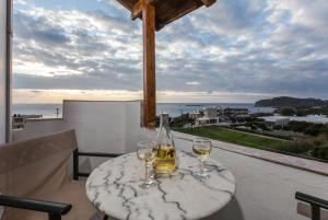 a table with two glasses of wine on a balcony at Aqua Marine in Falasarna