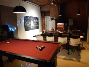 a room with a pool table and chairs at Casa Esquina do Mar in São Francisco do Sul