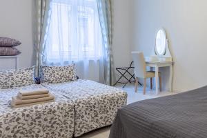 a bedroom with a bed and a desk and a mirror at Goldcentral Apartment Grand Boulevard in Budapest