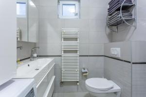 Un baño blanco con inodoro y lavabo. en Goldcentral Apartment Grand Boulevard In The Heart Of The City, en Budapest 20 fotos más
