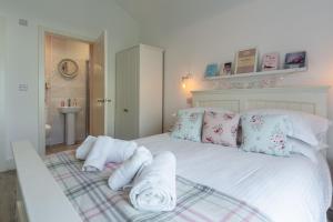 a bedroom with a white bed with towels on it at Miss Fishers in Port Isaac