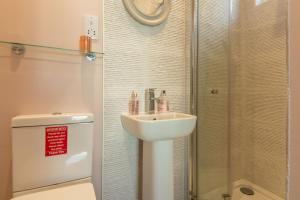 a bathroom with a white sink and a shower at Miss Fishers in Port Isaac