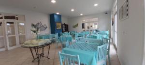 une salle à manger avec des tables et des chaises bleues dans l'établissement Hotel Porto de Paz - Shantiniketan, à São Francisco do Sul