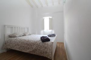 Habitación blanca con cama y ventana en Comfortable apartment with character in the old town, en Palma de Mallorca
