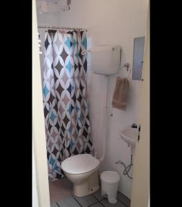 a bathroom with a toilet and a shower curtain at Casa na Ilha da Croa in Barra de Santo Antônio