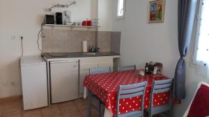 une cuisine avec une table et une table et des chaises rouges dans l'établissement L'appartement de l'église, à Saintes-Maries-de-la-Mer
