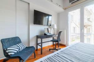 アテネにあるElpis by Heloni Apartmentsのベッドルーム(デスク、椅子、テレビ付)