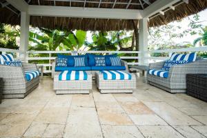 a patio with blue and white chairs and a table at Blue Paloma Bed & Breakfast in Lucea