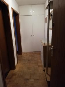 ein Badezimmer mit weißen Schränken und Holzböden in der Unterkunft Appartements am Park in Bad Krozingen