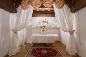 baño con bañera blanca y lámpara de araña en Corte Dei Neri, en Florencia