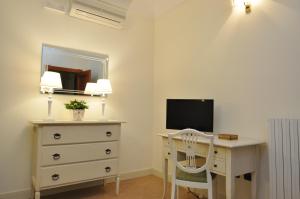 una camera da letto con scrivania, TV e cassettiera di Villa Marcella Room a Porto Cesareo