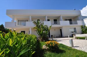 una grande casa bianca con un giardino davanti di Villa Marcella Room a Porto Cesareo