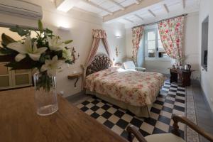 フィレンツェにあるコルテデイネリ レジデンツァ デポカのベッドルーム1室(ベッド1台、テーブルの上に花瓶1枚付)