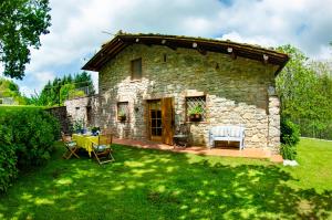 a stone cottage with a table and chairs in a yard at Grumo in Loppeglia