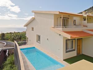 a villa with a swimming pool and a view of the ocean at Arco da Calheta Villa in Arco da Calheta