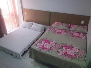 1 dormitorio con 2 camas con flores en Condomínio Lagoa Quente Flat Service-Caldas Novas - FLAT TOP, en Caldas Novas