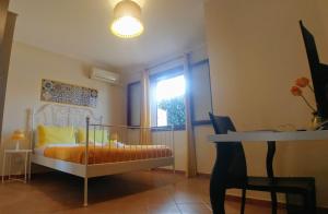 een slaapkamer met een bed, een raam en een tafel bij Ciuri ri zagara in Cinisi