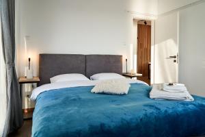 a bedroom with a large bed with a blue blanket at Seafront Luxury President Suite Aegean Sunset in Thessaloniki