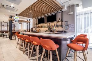 a bar in a restaurant with orange stools at Holiday Inn - Columbia - Downtown, an IHG Hotel in Columbia