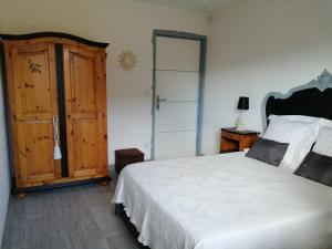 um quarto com uma cama branca e uma porta de madeira em AU VILLADIOR - Vaison la Romaine em Vaison-la-Romaine
