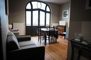 een woonkamer met een tafel en stoelen en een raam bij The Nest in Amiens