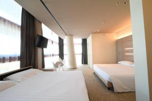 a hotel room with two beds and a tv at Best Western Plus Net Tower Hotel Padova in Padova