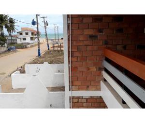 a brick wall next to a building next to a street at Casa na Ilha da Croa in Barra de Santo Antônio