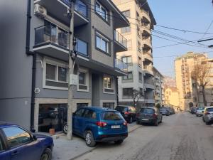 un coche azul estacionado frente a un edificio en ELENA LUX, en Užice