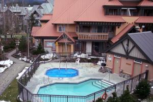 une grande maison avec une piscine en face de celle-ci dans l'établissement Stoney Creek Sunpath by Whistler Premier, à Whistler