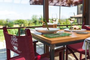 a wooden table with glasses of wine and food on it at Torre di Baratti Bio Resort in Populonia