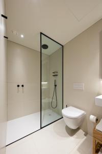 a bathroom with a shower, toilet, and sink at BessaApartments in Porto