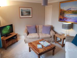 a living room with a couch and a coffee table at Rocking Chair Farmhouse in Alnwick