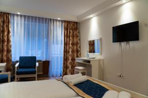 a hotel room with a bed and a chair and a television at Hotel Eleon in Bad Teinach-Zavelstein