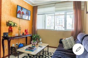 a living room with a couch and a table at Edifício Andressa in Florianópolis