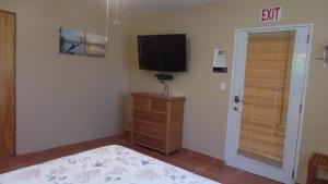 a bedroom with a television and a dresser at Isla Hermosa Guesthouse in Vieques