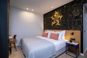 a bedroom with a bed and a wall with a painting at Artist Hotel - an Atlas Boutique Hotel in Tel Aviv