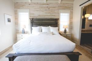 a bedroom with a large white bed and two windows at Kaya Cottages in Dahlonega