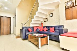 a living room with a blue couch and red pillows at Hotel Sakhi inn by Urban Galaxy in Amritsar