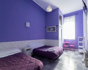 Dormitorio púrpura con 2 camas y mesa en Pensión Apolo XI, en Madrid
